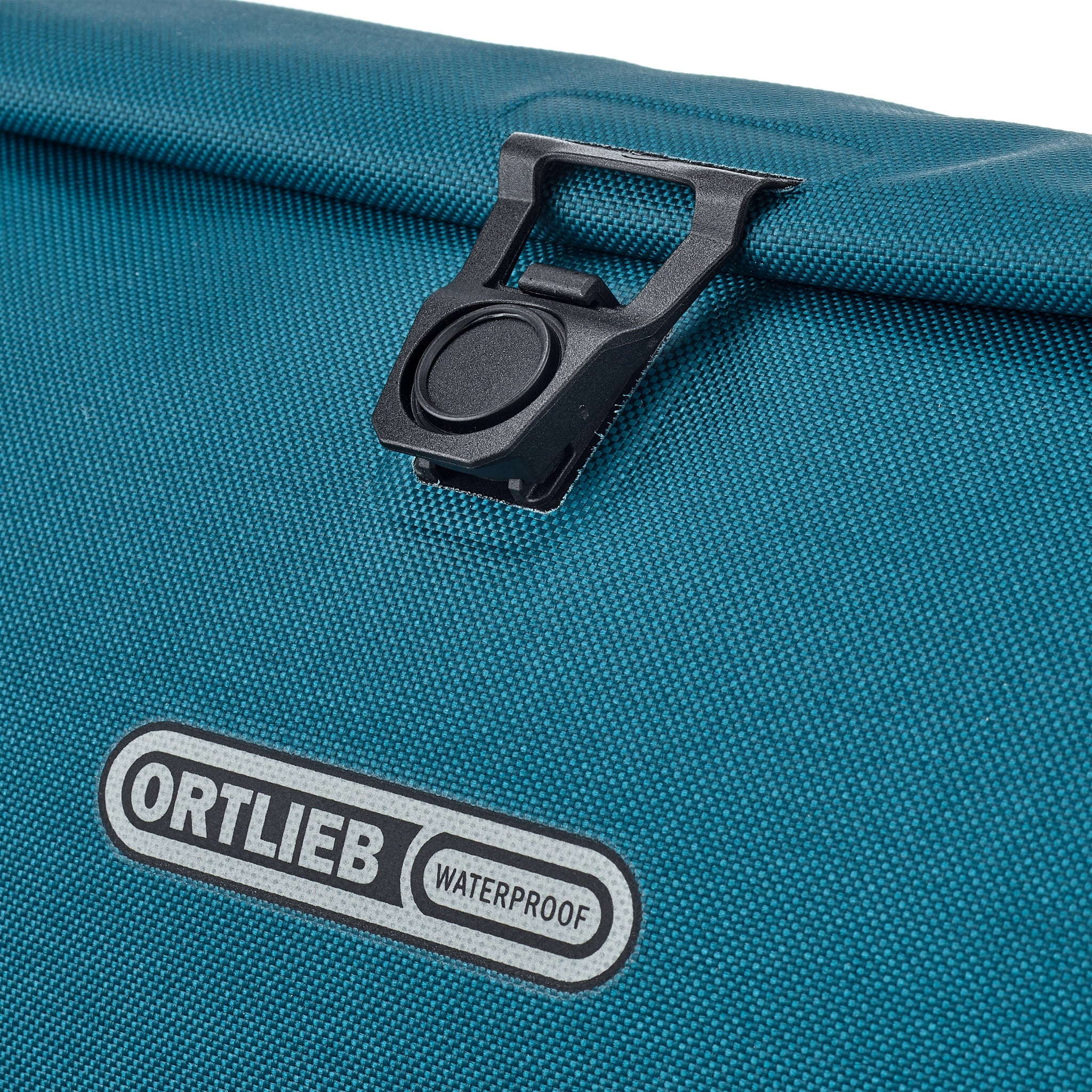 Detailaufnahme der ORTLIEB Velo-Sling Flex in petrol mit Magnetverschluss und Logo