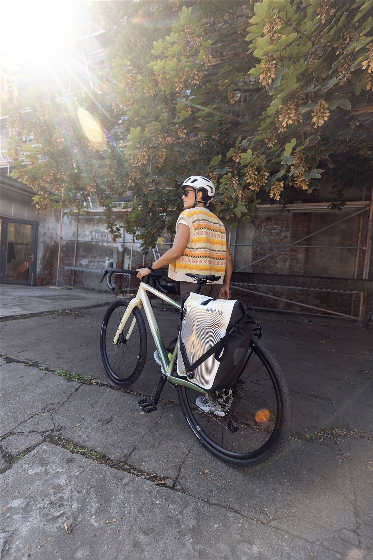 Woman sitting on bench beside bicycle with ORTLIEB Back-Roller Design bag in Route No.1