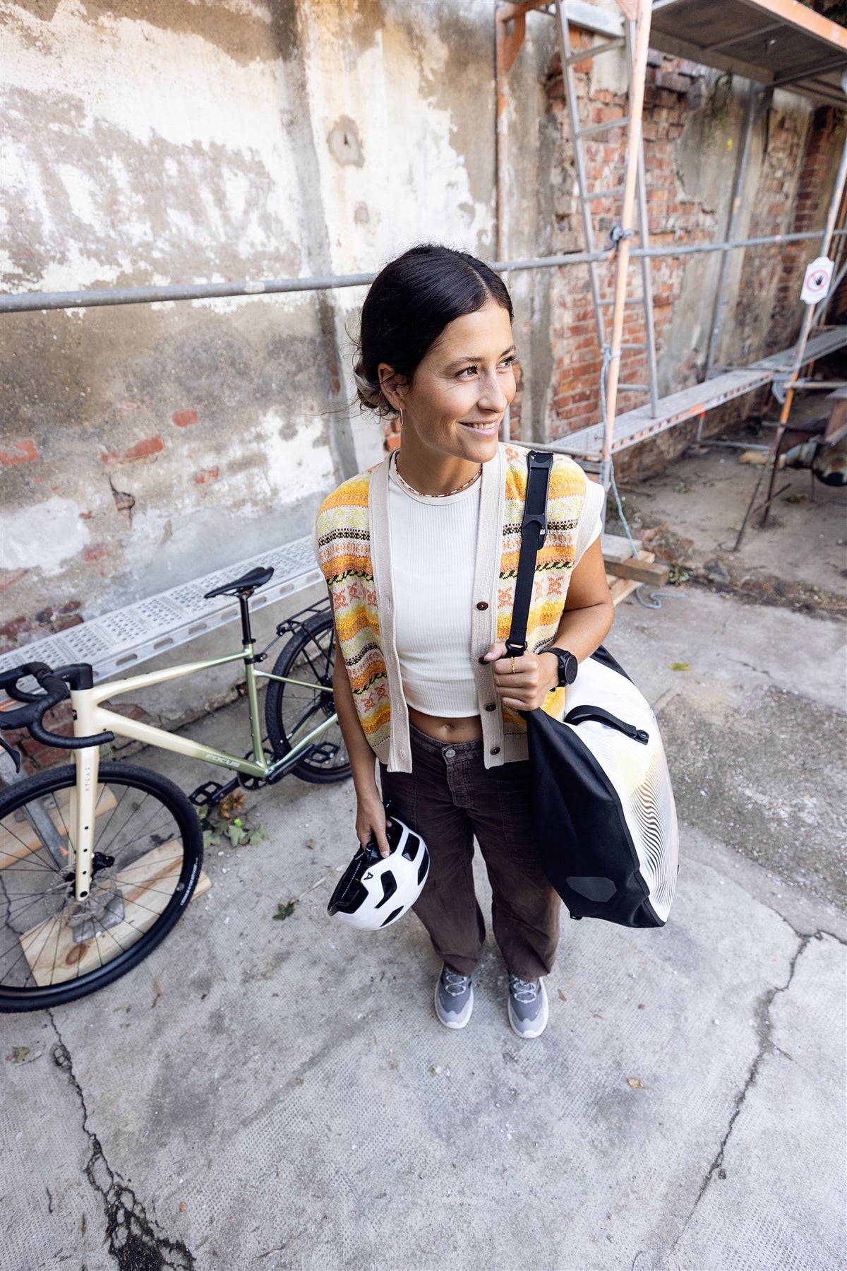 Woman carries ORTLIEB Back-Roller Design bag in Route No.1 with yellow-orange line pattern