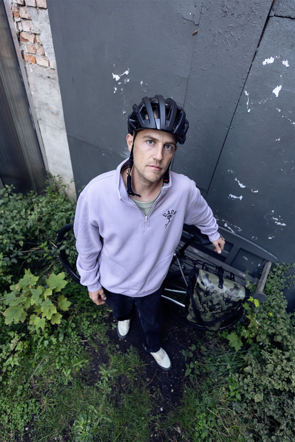 Man carrying bicycle with ORTLIEB Back-Roller Design bag in camouflage olive up a staircase