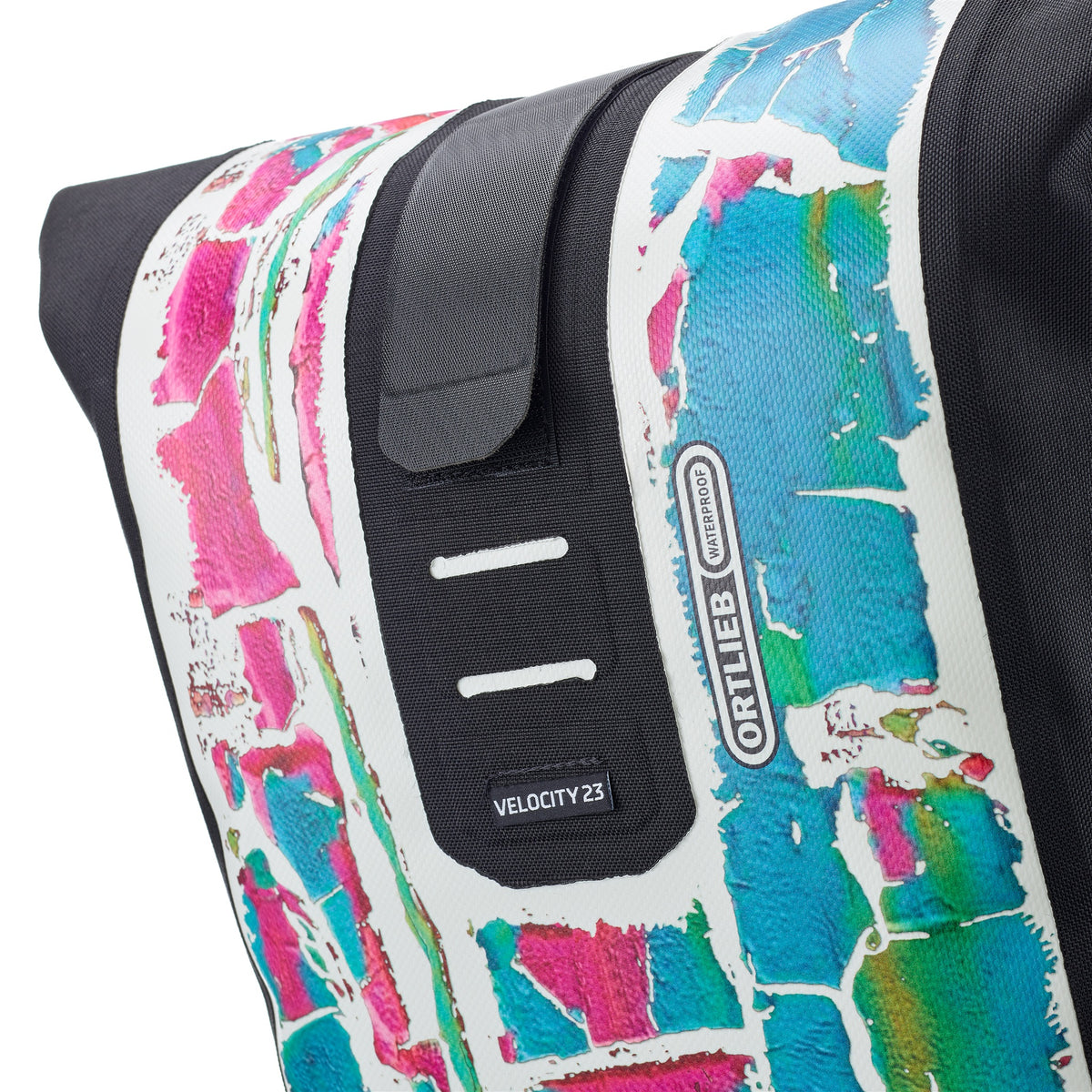 Man wearing ORTLIEB Velocity Design backpack with pink turquoise white pattern on city walk
